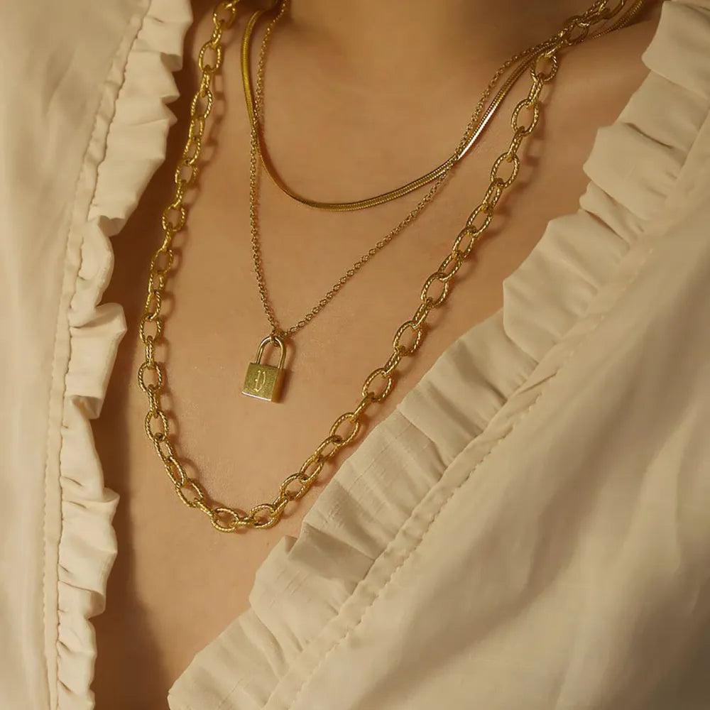 Cadena moderna dorada de 18 quilates con iniciales y candado
