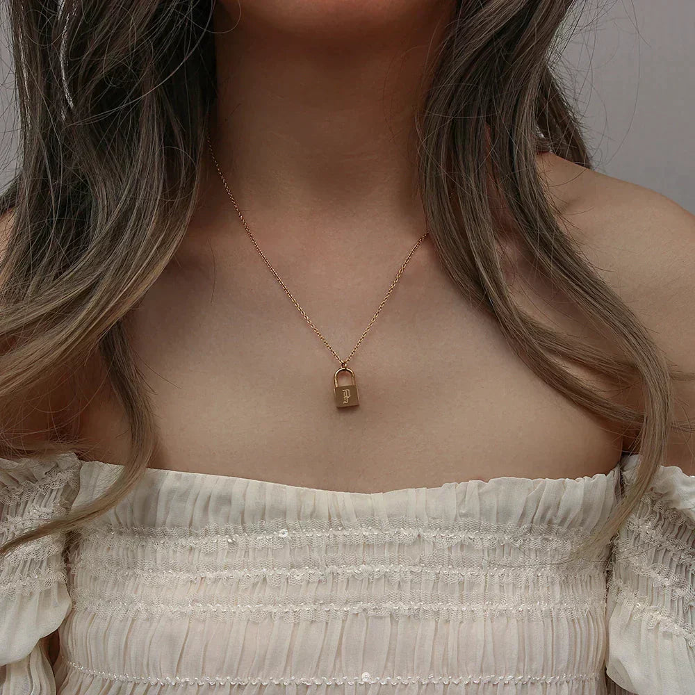 Cadena moderna dorada de 18 quilates con iniciales y candado